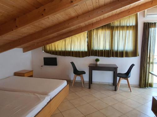 a bedroom with a bed and a table and chairs at Ionion Studios in Kanali