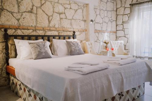 1 dormitorio con 1 cama grande con sábanas y almohadas blancas en Deruni Ilıca en İzmir