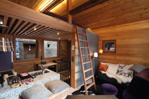 una sala de estar con una escalera en una cabaña de madera en Nid d'Amour, le Nain., en Albinen