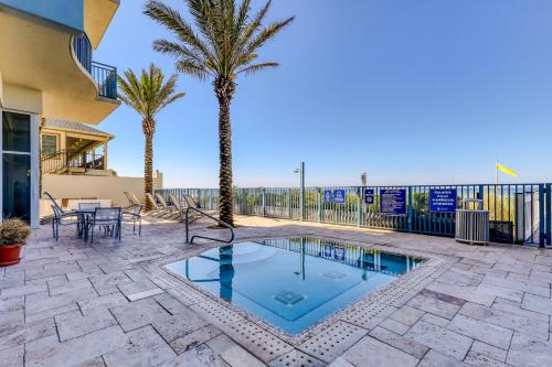 a patio with a swimming pool with palm trees at Sterling Breeze 3 in Panama City Beach