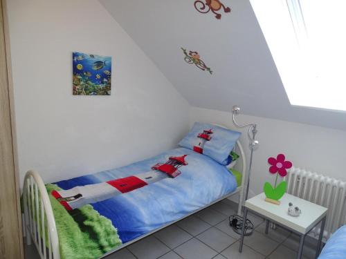Un pequeño dormitorio con una cama con una muñeca. en 50108 Ferienhaus Cliner Sünn Whg. Baltrum en Carolinensiel