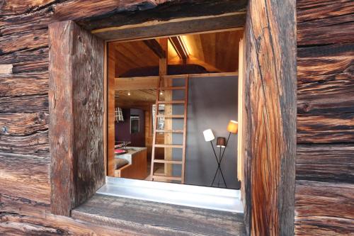 una ventana en una cabaña de madera con espejo en Nid d'Amour, le Nain., en Albinen