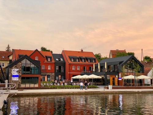 a group of buildings next to a body of water at Kurort Kameralny in Mikołajki