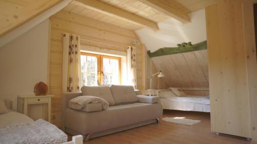 a living room with a couch and a bed at Willa Pod Słońcem in Zakopane