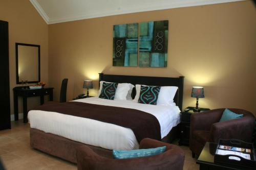 a hotel room with a large bed and chairs at Destiny Lodge in White River