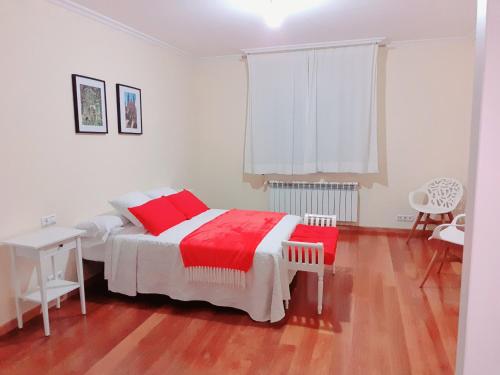 a bedroom with a bed with a red blanket on it at Estrella Do Camiño in Caldas de Reis