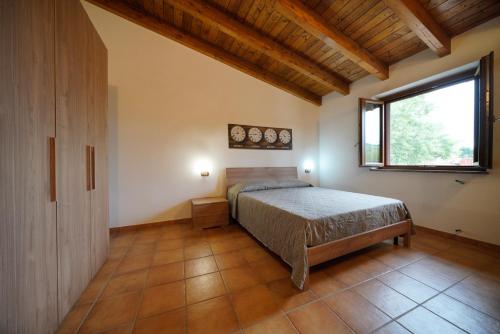Schlafzimmer mit einem Bett und einem Fenster in der Unterkunft L'oliveto in Nuxis