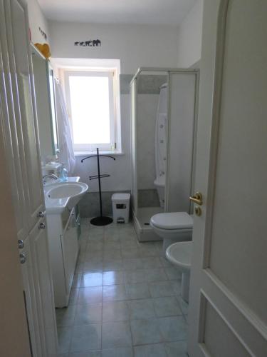 łazienka z umywalką, toaletą i oknem w obiekcie L'Elefantino - Bed and Book w mieście Roccasparvera