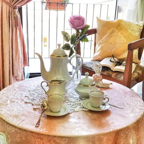 a table with a tea kettle and cups on it at Bettyhome in Cariati