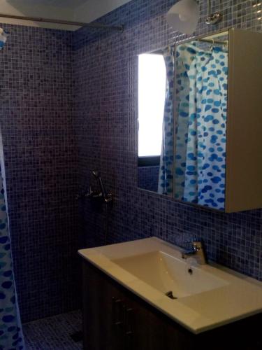 a bathroom with a sink and a mirror at Ithaca's Poem Apartments in Vathi, Ithaka