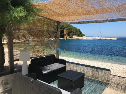 Una silla y una mesa en una playa con el océano. en Stiniva beach house, en Brusje