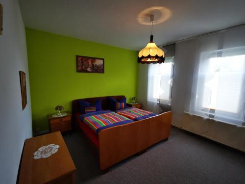 a bedroom with a bed and a green wall at Auszeit auf dem Land nahe Ludwigslust in Glaisin