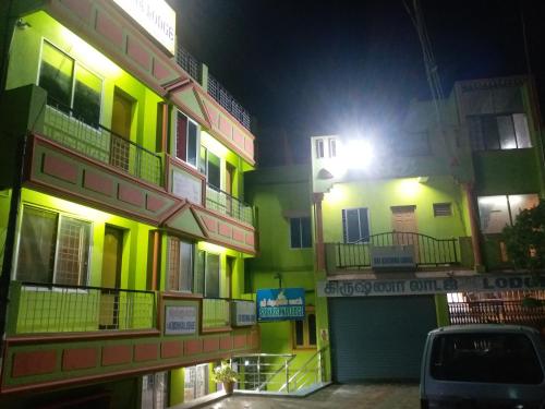 a building with yellow and green with a street light at SRI KRISHNA LODGE in Hosūr