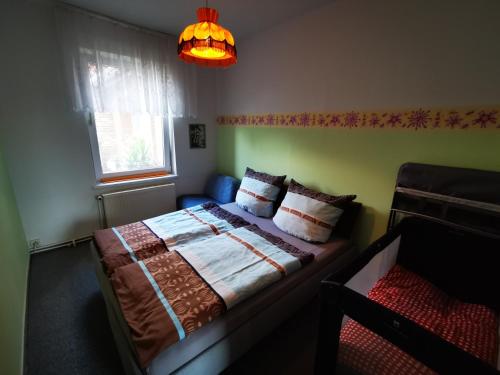 a bedroom with a bed and a window and a lamp at Auszeit auf dem Land nahe Ludwigslust in Glaisin