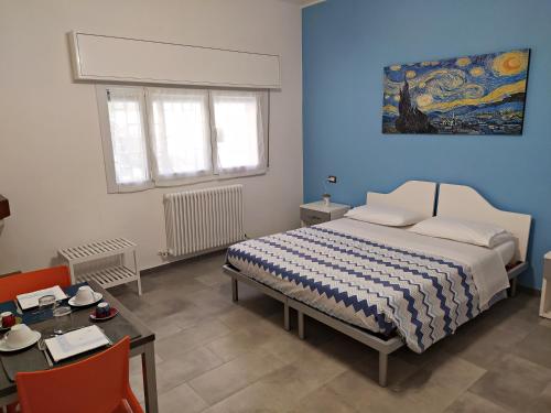 um quarto com uma cama, uma mesa e um quadro em ROOM AND BREAKFAST SAN RAFEL em Bolonha