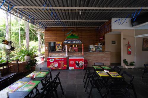 a restaurant with tables and chairs and a food cart at Hotel Fazenda Pé da Serra in Bom Sucesso