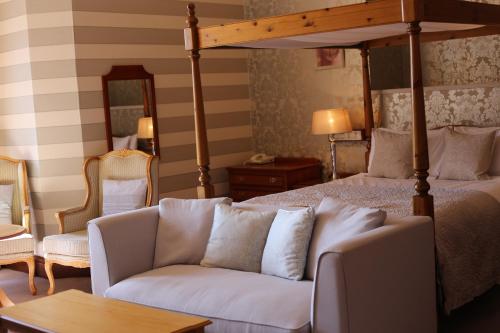 a living room with a bed and a couch at Pitlochry Dundarach Hotel in Pitlochry