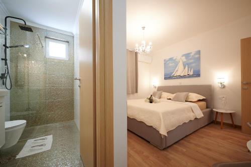 a bedroom with a bed and a bathroom with a shower at Rooms Antonio in Trogir