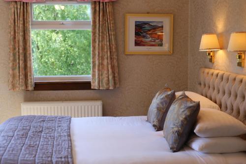 A bed or beds in a room at Pitlochry Dundarach Hotel 