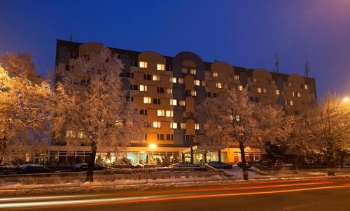 a large building with trees in front of a street at Hotel Mieszko in Gorzów Wielkopolski