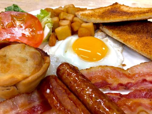 a plate of breakfast food with eggs bacon sausage and toast at Motel Chantmartin in Tadoussac