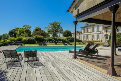 une terrasse en bois avec des chaises et une piscine dans l'établissement Séjour à la campagne -Domaine de Cézac, à Cézac