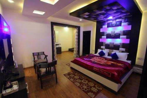 a bedroom with a large bed with purple lighting at AS Clarks inn in Dalhousie