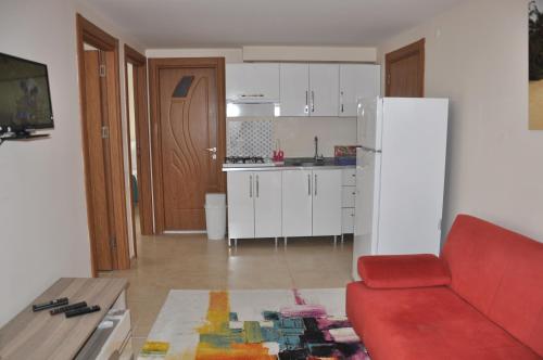 a kitchen with a red couch and a white refrigerator at Neoss Boutique Hotel in Siğacık