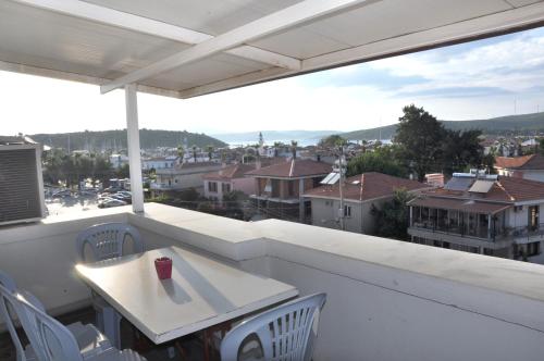 a balcony with a table and chairs and a view of a city at Neoss Boutique Hotel in Siğacık