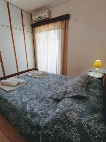 a bedroom with a bed with a blue comforter at 85 sqm Apartments New Panorama ELECTRIC CAR ΦΩΡΤΗΣΗΣ STATION in Paralion astros