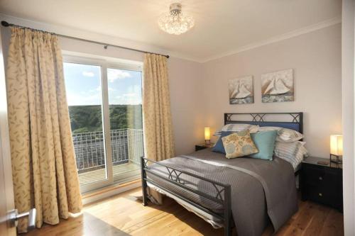 sypialnia z łóżkiem i dużym oknem w obiekcie Redcliffe House w Looe