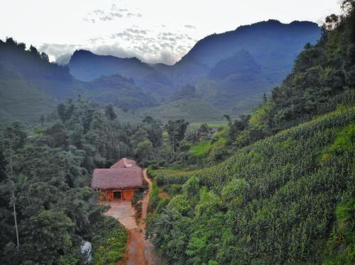 a house on a dirt road in a mountain valley at Chô Family in Bắc Hà