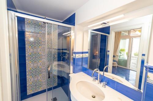 uma casa de banho azul com uma banheira e um lavatório em Casa Maresca Residence em Positano