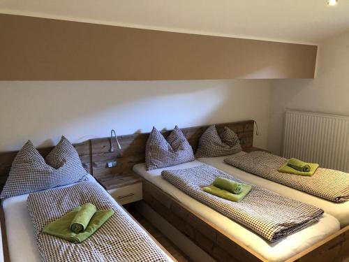 two beds in a room with green pillows on them at Haus Obertiefenbach in Radstadt