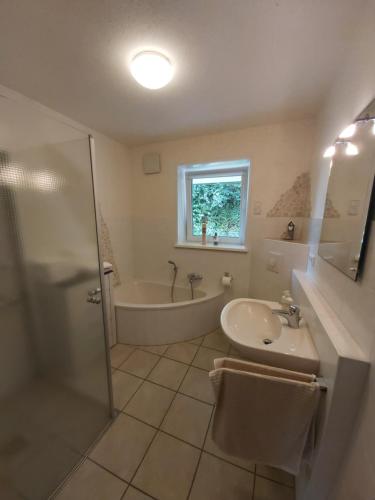 y baño con bañera, lavamanos y ducha. en Ferienwohnung Künzell, en Künzell