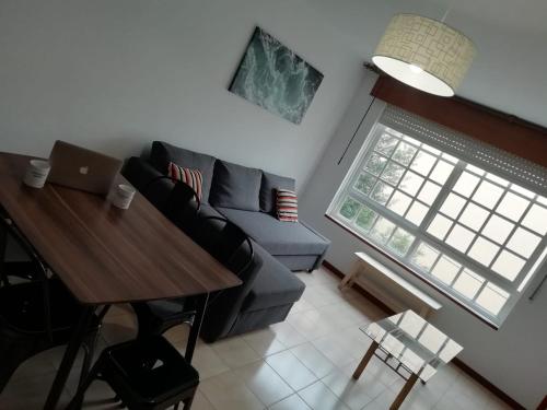 sala de estar con sofá y mesa en Portonovo Suites by Serendipia Turismo, en Sanxenxo