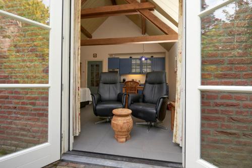 a porch with two chairs and a table at Huys en Hoff Aen Den Haspel in Oirschot