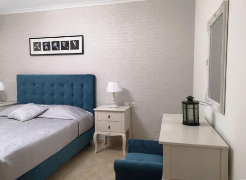 a bedroom with a blue bed and a blue chair at Pirofani Villa Apartments in Apolpaina