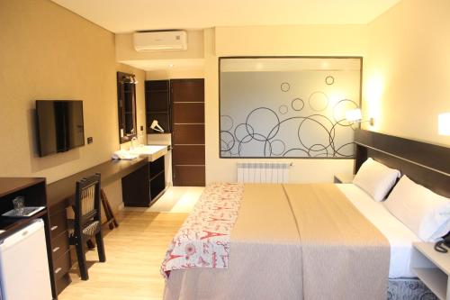 a hotel room with a bed and a bathroom at Altos De Merlo Suites in Merlo