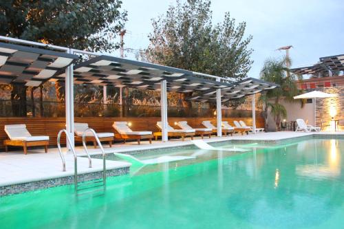 a swimming pool with chairs and a pavilionvisedasteryasteryasteryasteryasteryastery at Altos De Merlo Suites in Merlo