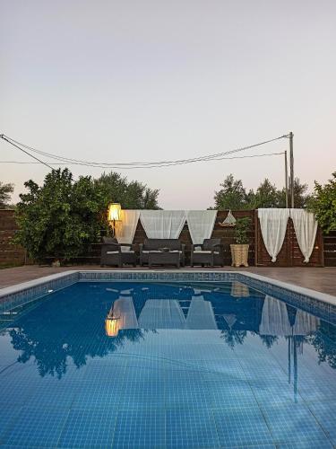 a large swimming pool with a table and chairs at Villa Lina in Pandokrátor