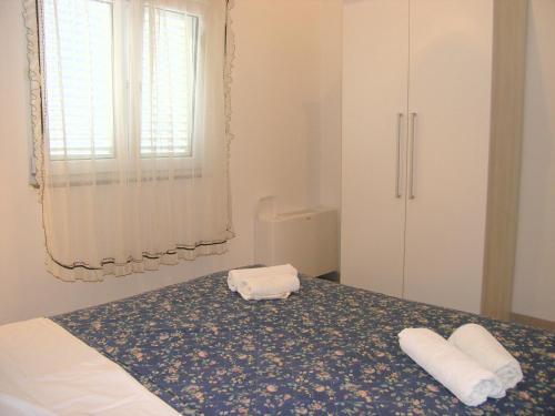 um quarto com uma cama com duas toalhas em Apartments Sokolović em Krk