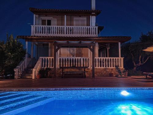 a house with a swimming pool in front of a house at Villa Lina in Pandokrátor