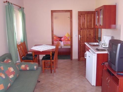 uma cozinha e uma sala de estar com uma mesa e uma televisão em Balla Appartements em Zalakaros