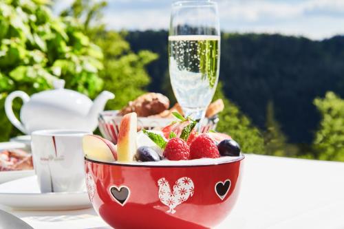 a bowl of fruit and a glass of wine on a table at Hotel Kronelamm im Schwarzwald in Bad Teinach-Zavelstein