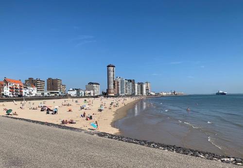 un groupe de personnes sur une plage près de l'eau dans l'établissement Bed by the Beach, à Flessingue