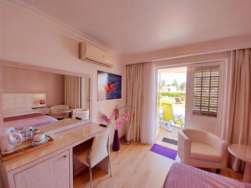 a hotel room with a bedroom with a desk and a bed at VILA FORMOSA AL-Estabelecimento de Hospedagem,Quartos-Rooms in Monte Gordo