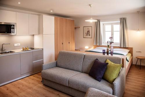 ein Wohnzimmer mit einem Sofa und einem Bett in der Unterkunft Puenlandhof in Bruneck