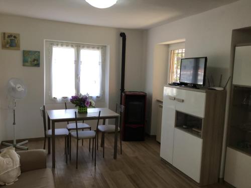 a living room with a table and a dining room at Casa Ginni con Piscina e giardino in Caravonica