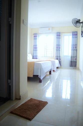 a bedroom with two beds and a large window at Khách sạn Phương Dung in Cửa Lò